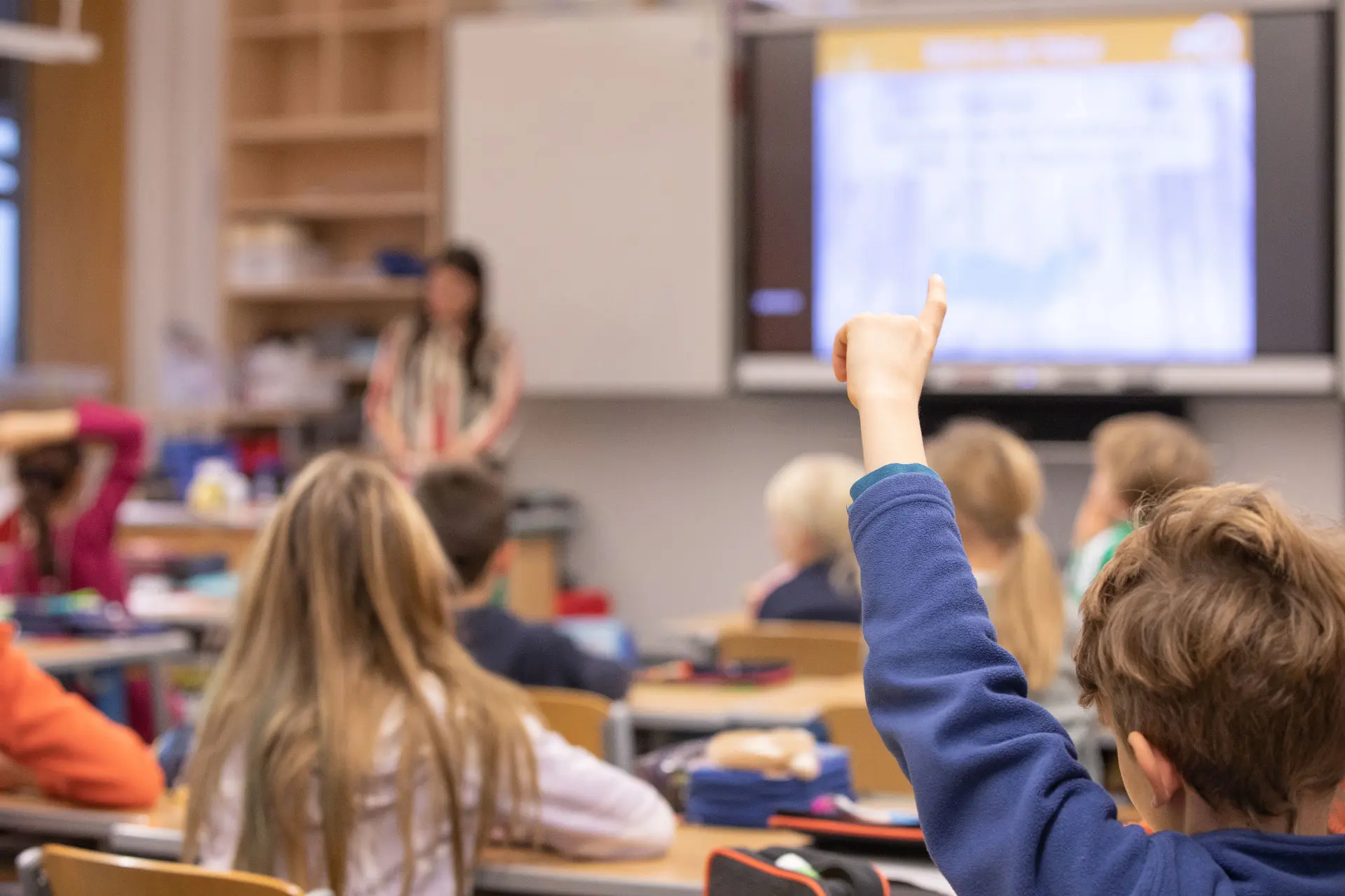 Kinder in einer Schulklasse, Kind meldet sich