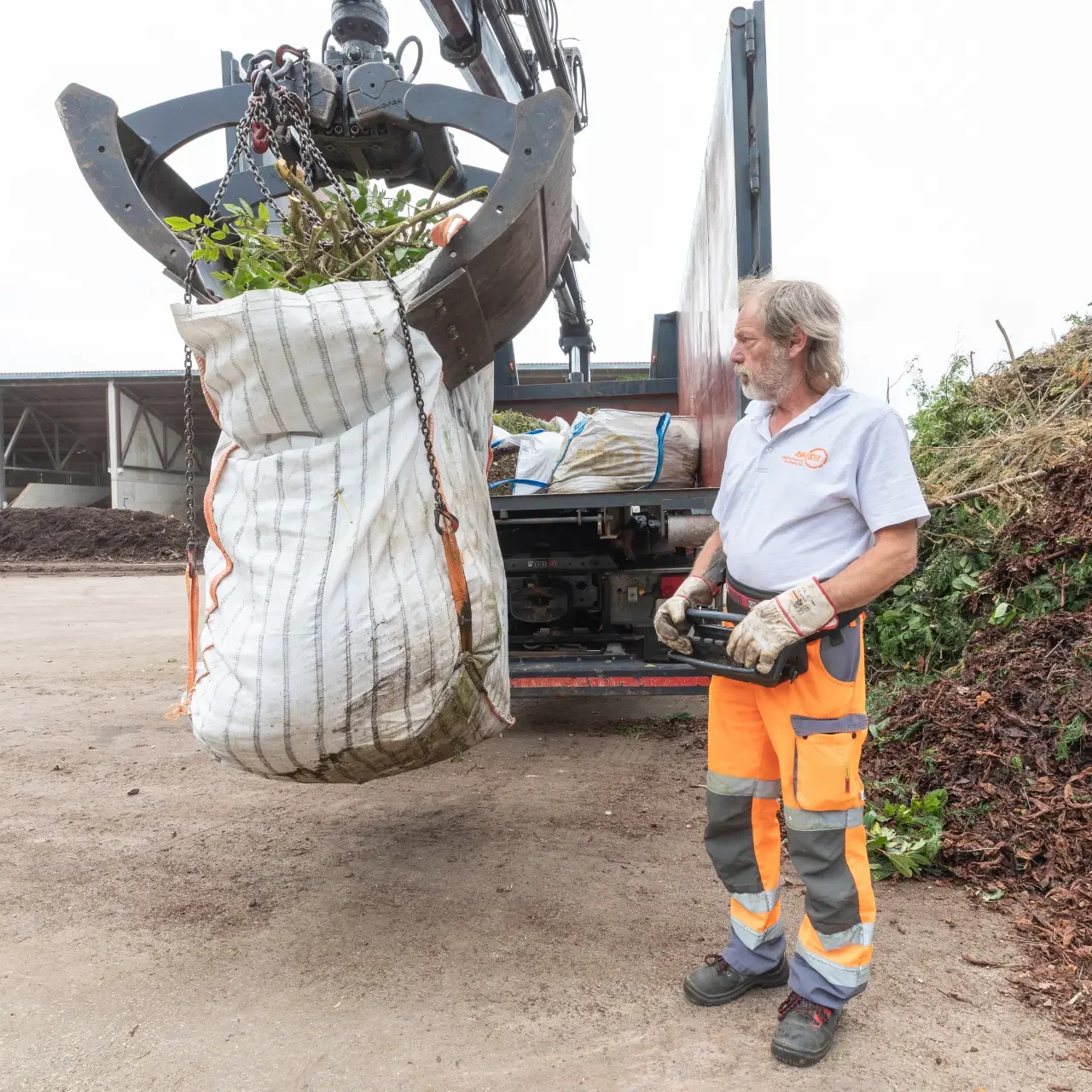 Grüngut-Bigbag wird von Greifarm hochgehoben